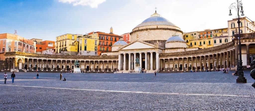 a large building with columns and a statue in front of it with Piazza del Plebiscito in the background