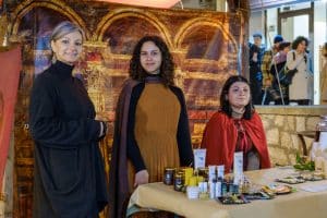 a group of women standing in front of a table with cosmetics